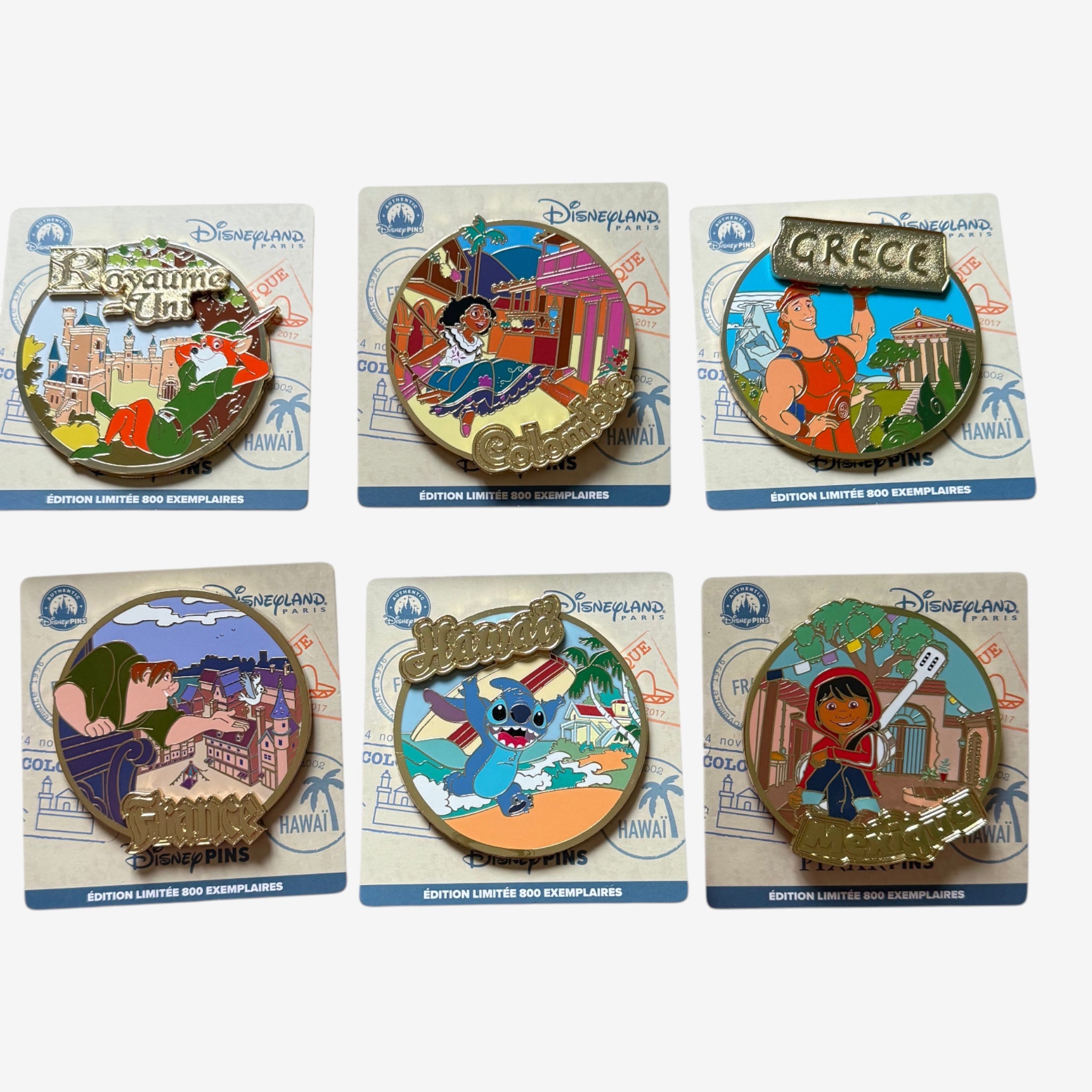 Once Upon Magic collection of six Disney character enamel pins featuring travel themes: Robin Hood in the UK, Mirabel in Colombia, Hercules in Greece, Quasimodo in France, Stitch in Hawaii, and Miguel from Coco.