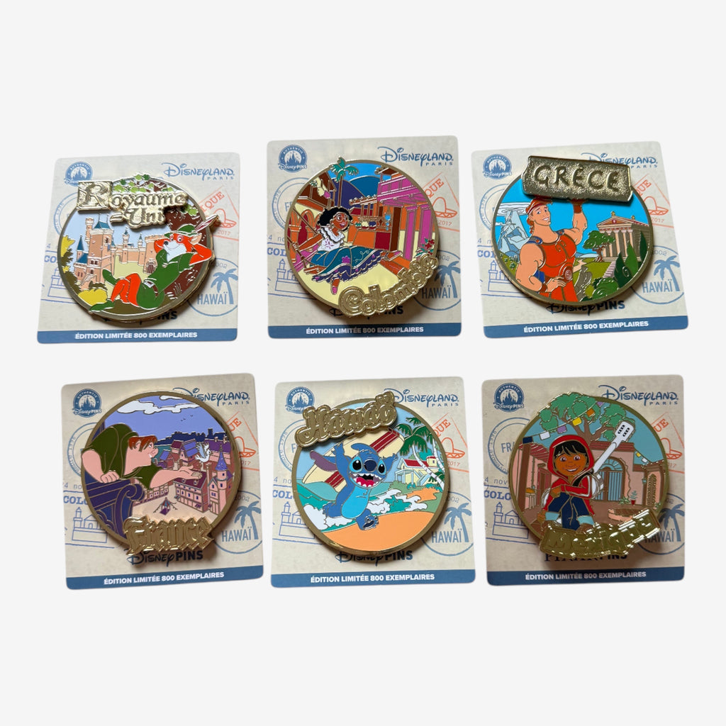 Once Upon Magic collection of 6 Disneyland Paris limited edition pins featuring characters and landmarks from various countries: UK, Colombia, Greece, France, Hawaii, and Mexico.