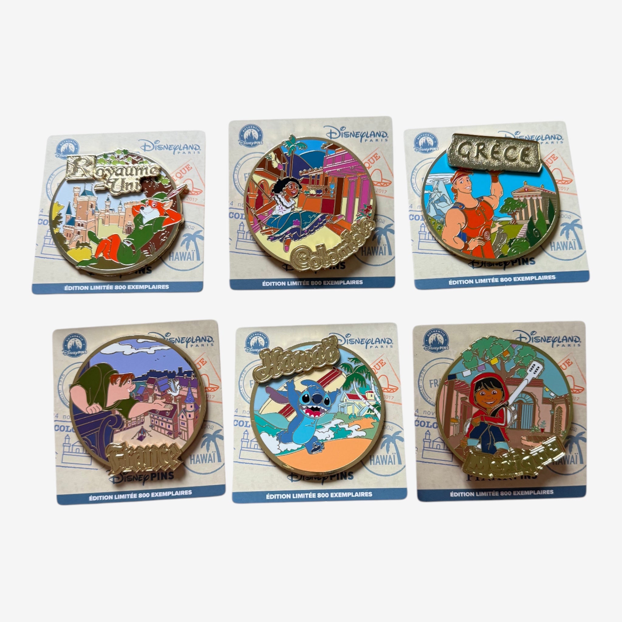 Once Upon Magic collection of 6 Disneyland Paris limited edition pins featuring characters and landmarks from various countries: UK, Colombia, Greece, France, Hawaii, and Mexico.