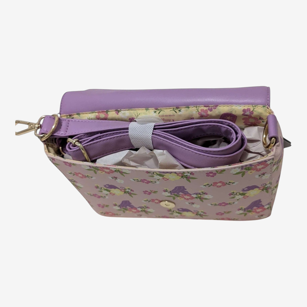 Once Upon Magic floral sun crossbody bag in lavender with pink floral print and gold hardware. Adjustable strap.