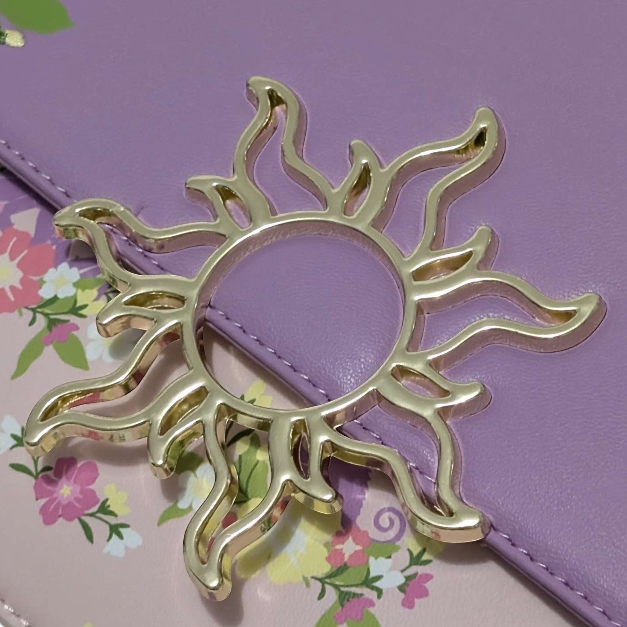 Once Upon Magic Floral Sun Crossbody Bag in lavender and pink with floral print and sun emblem. Features a silky scarf handle.