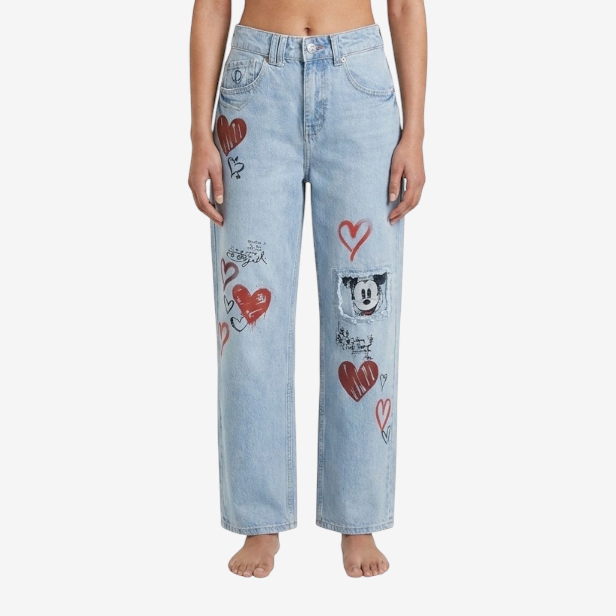 Light wash denim jeans with red heart graphics and a Mickey Mouse patch, from Desigual x Disneyland Paris collection.