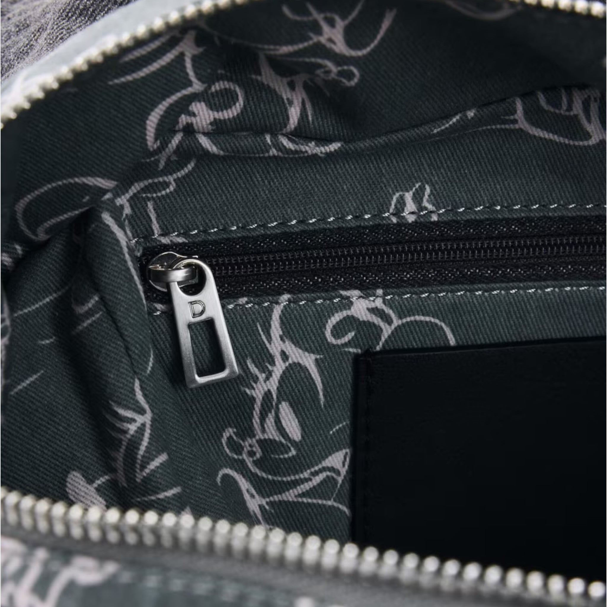 Once Upon Magic Mickey Mouse backpack interior with charcoal grey lining and a zip pocket. Features a subtle Mickey Mouse pattern.