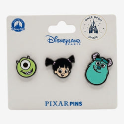 Once Upon Magic Disneyland Paris enamel pin set featuring stylized portraits of Monsters Inc characters Mike Wazowski, Boo, and Sulley.