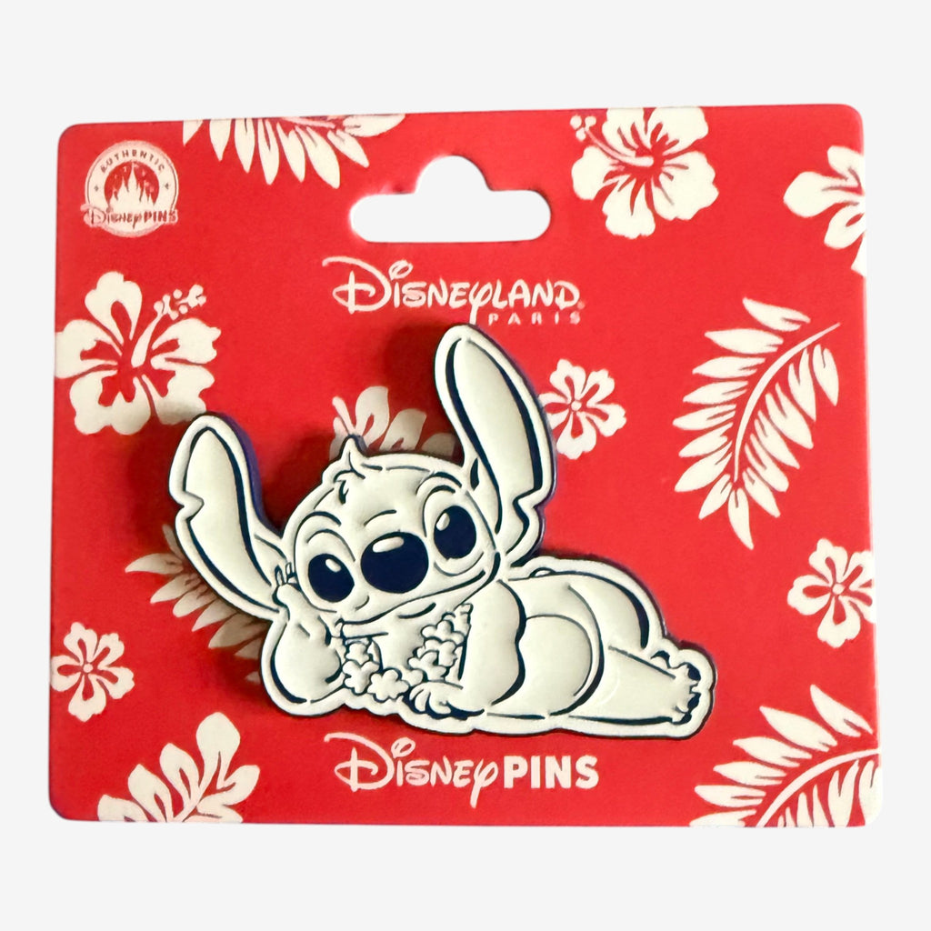 Pin's Stitch Allongé de la collection Hawaï de Disneyland Paris, avec Stitch couché entouré de fleurs d'hibiscus sur fond rouge.