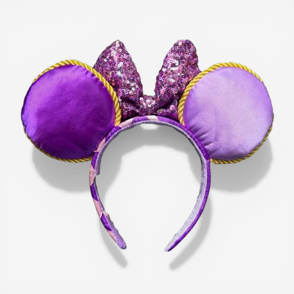 Once Upon Magic Minnie ears headband with purple satin ears, sequined bow, and gold trim, inspired by Rapunzel.