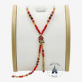 Once Upon Magic beaded lariat necklace with red and gold beads, featuring a rose charm and deep red crystal accents. Adjustable design.
