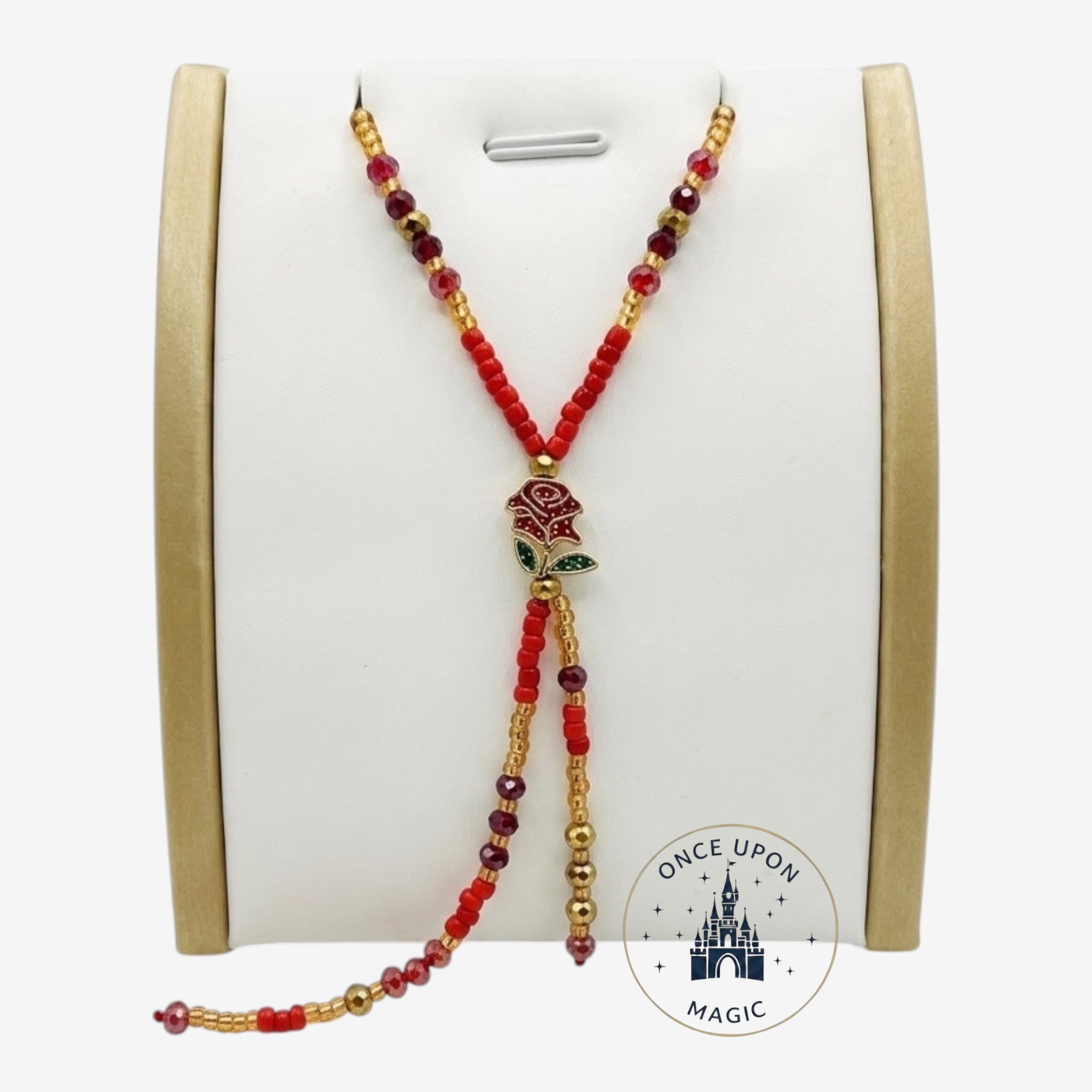 Once Upon Magic beaded lariat necklace with red and gold beads, featuring a rose charm and deep red crystal accents. Adjustable design.