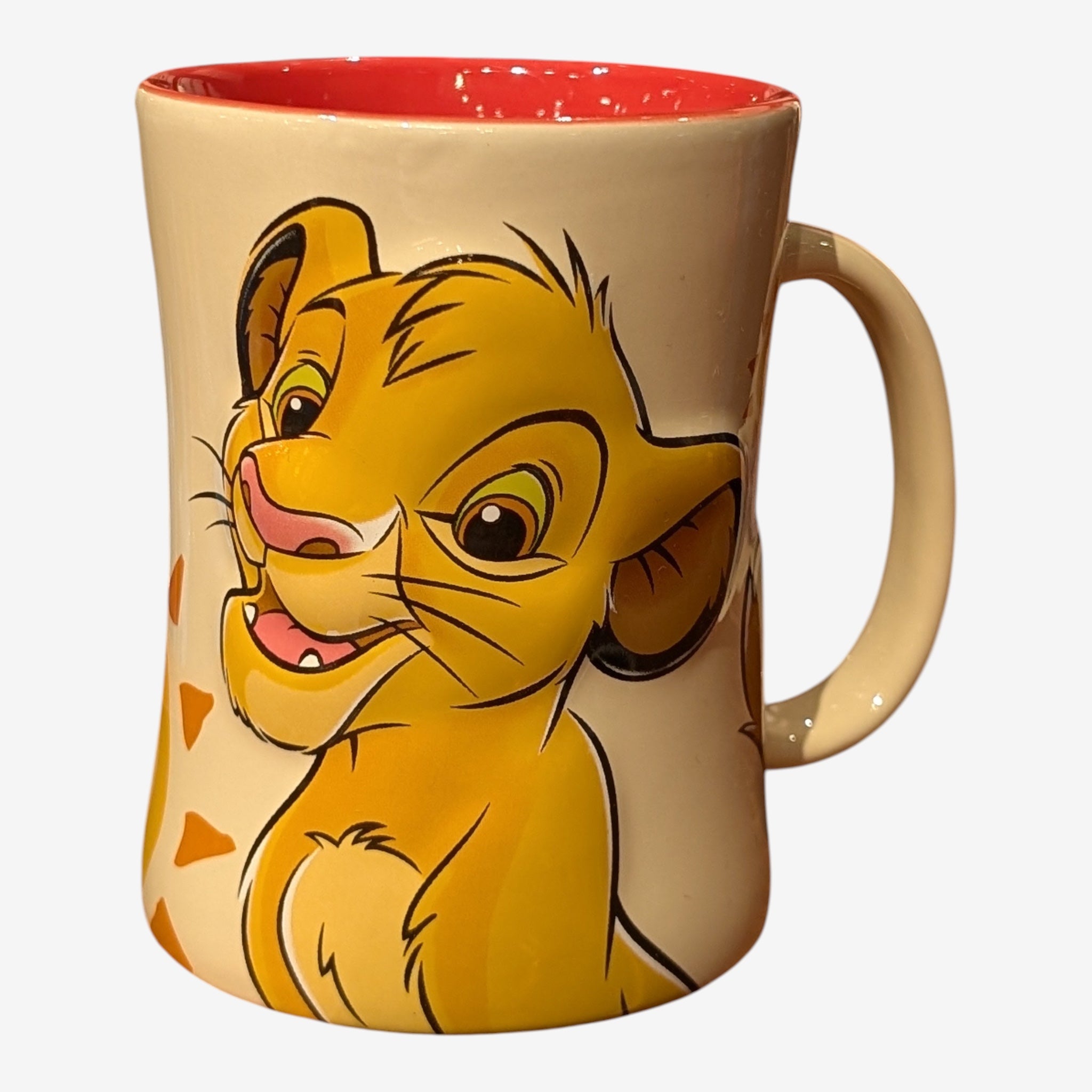 Once Upon Magic cream ceramic mug featuring a smiling Simba from The Lion King, with a red interior and sun-like patterns.