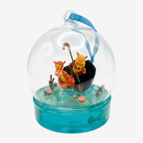 Once Upon Magic clear glass ornament featuring Winnie the Pooh and Tigger in a boat with lily pads and frogs.
