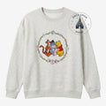 Once Upon Magic light grey crewneck sweatshirt with Winnie the Pooh, Tigger, Eeyore, and Piglet graphic in a floral wreath.